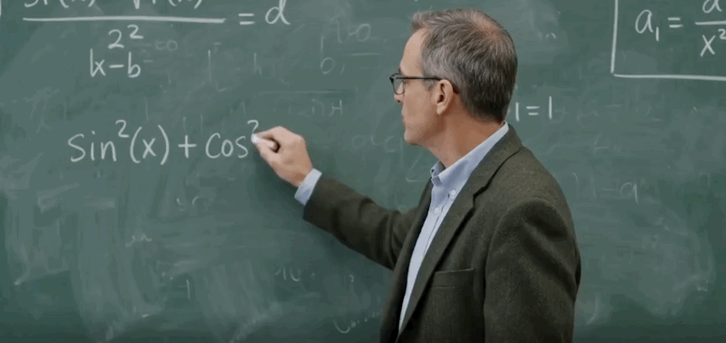 professeur écrivant une formule au tableau dans une salle de classe.