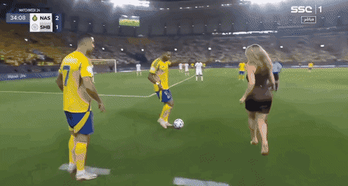 Scène immersive dans un stade de football générée par IA montrant des joueurs et une interaction en bord de terrain